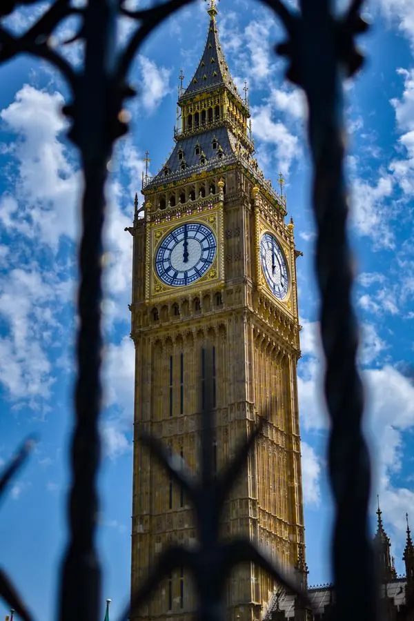 Big Ben clock tower through an iron fence, London