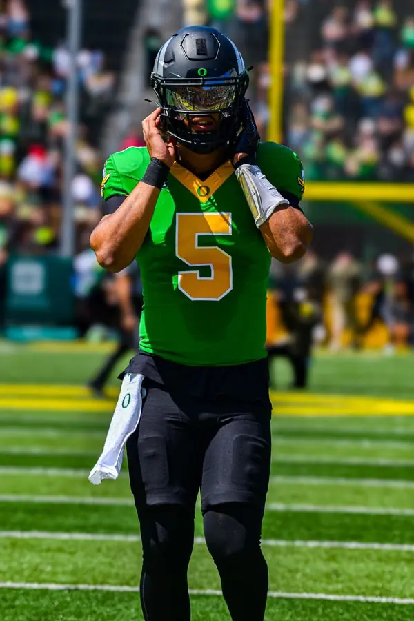 Football player adjusting helmet on the field