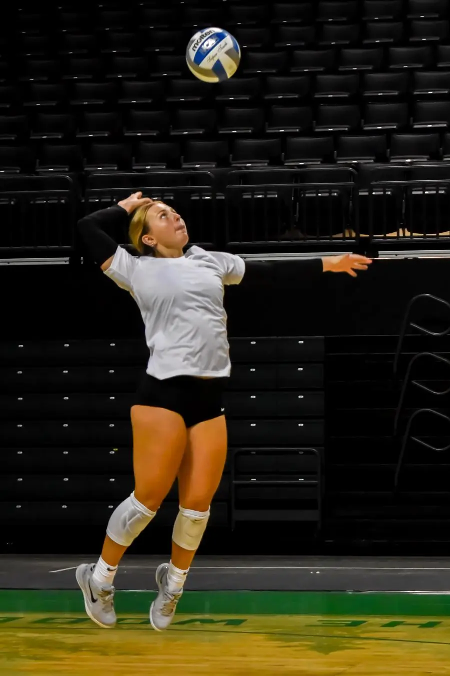 Oregon volleyball player jumping to serve