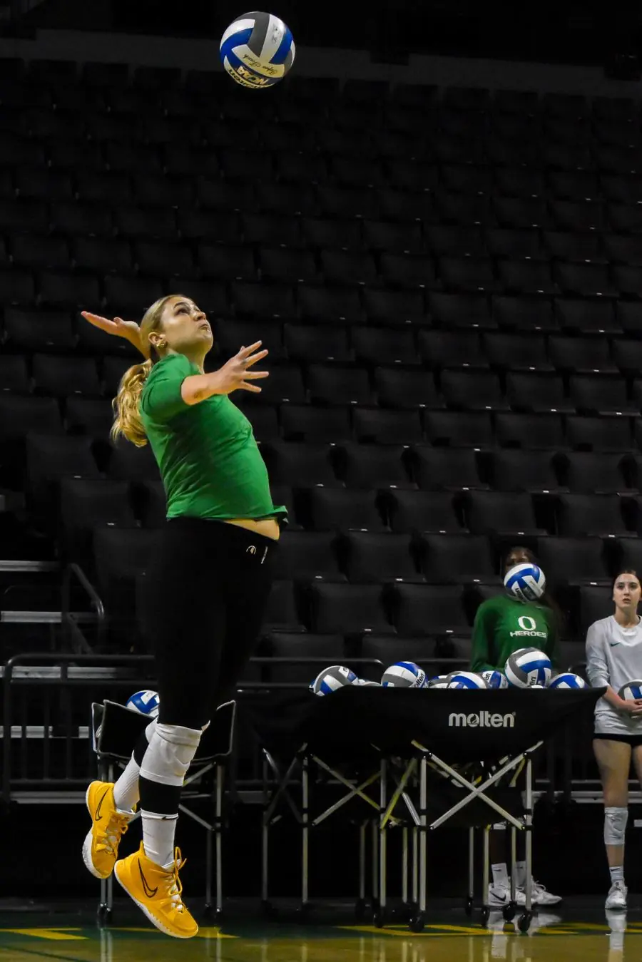 Oregon volleyball player serving toward camera