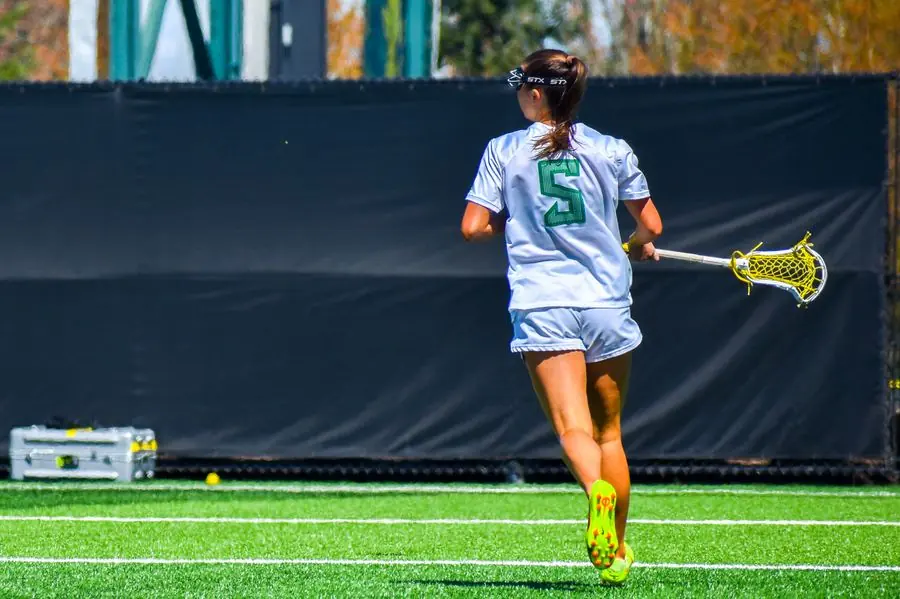 Oregon lacrosse player number 5 running upfield