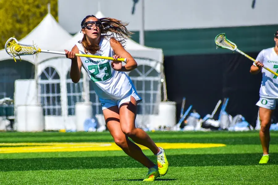 Oregon lacrosse player cutting upfield, number 23