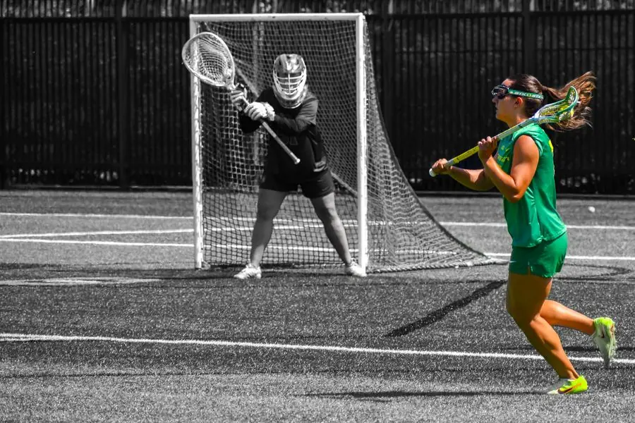 Oregon lacrosse player shooting on goal, black and white with color pop